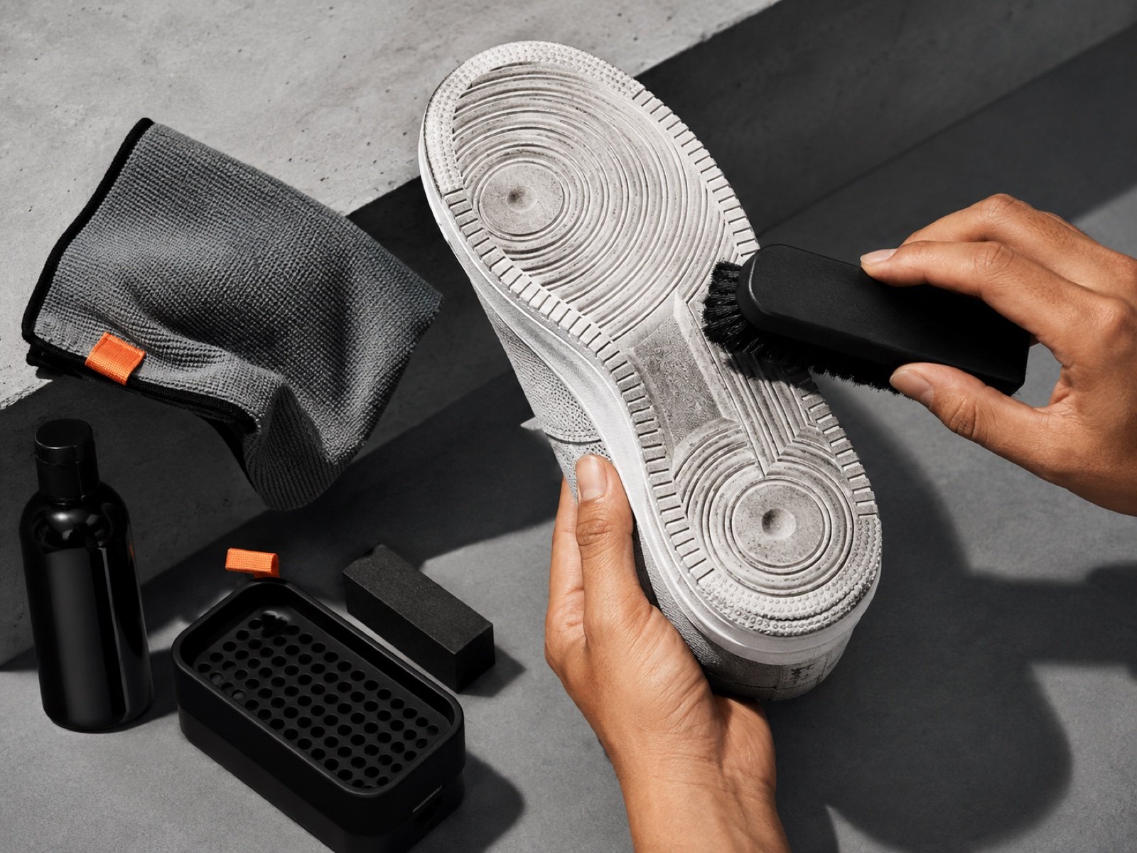 Sneaker brush, cloth and cleaning kit on concrete