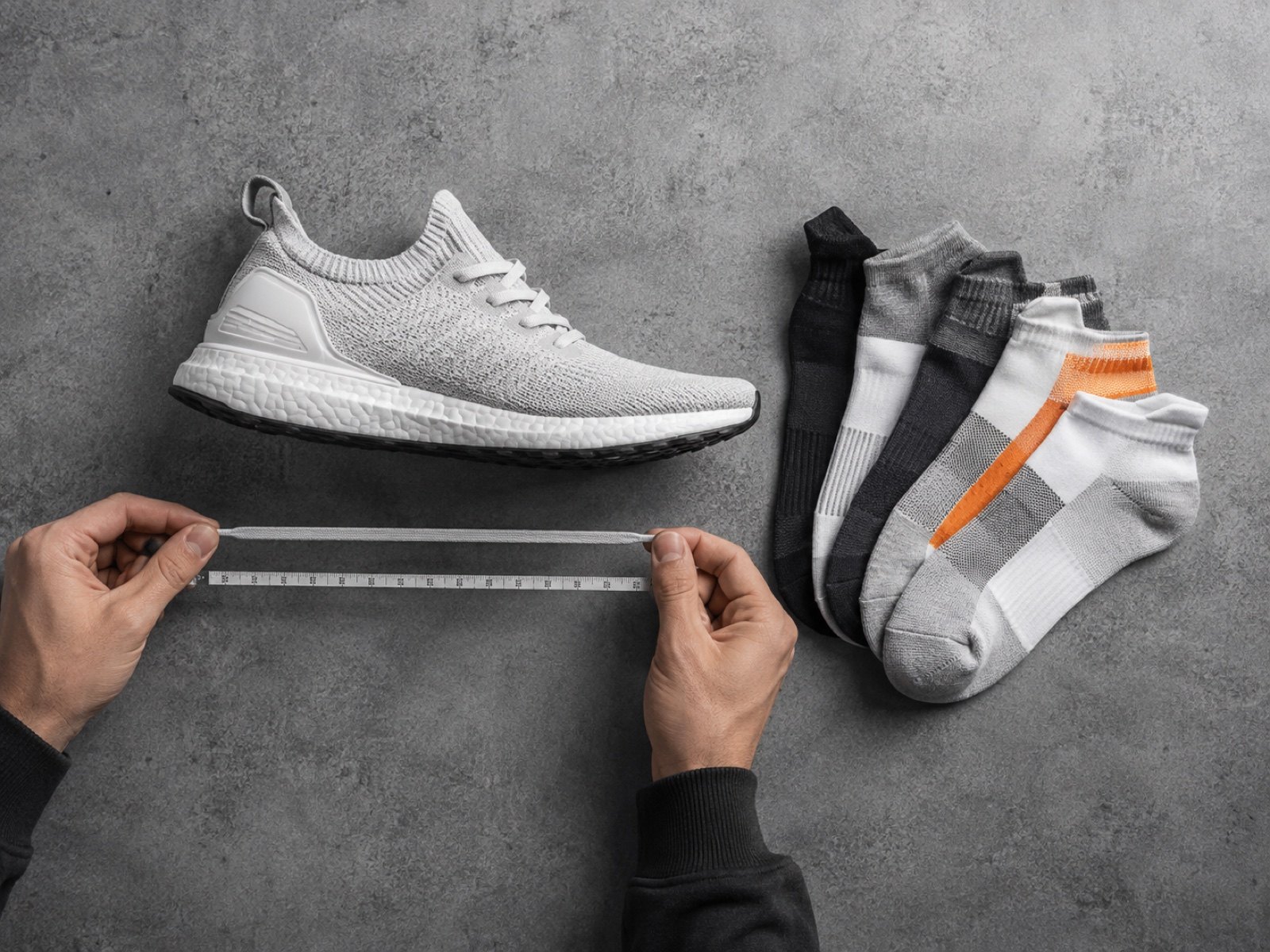 Hands measuring sneaker laces and checking sock sizes